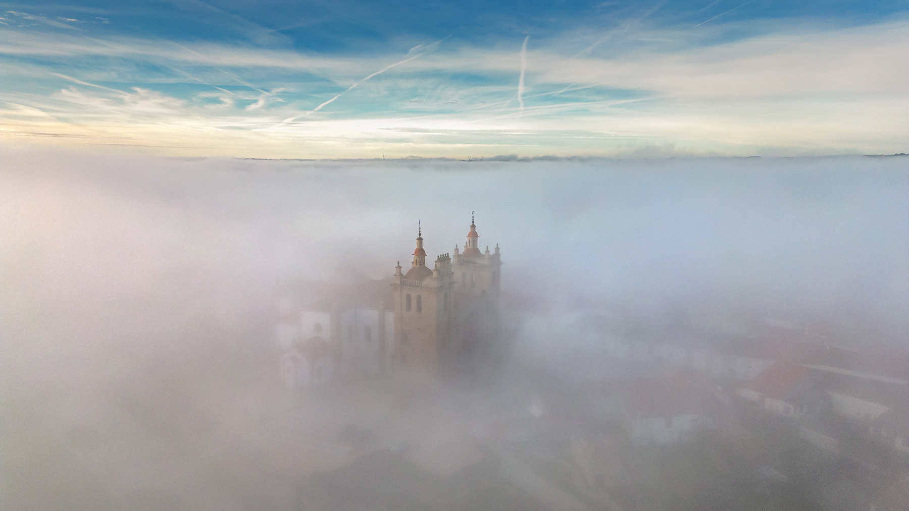 Vista aérea da Concatedral de Miranda do Douro emergindo do nevoeiro.